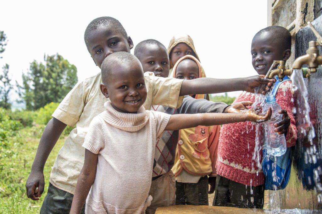 Kinderen in Tamu staan bij waterkraan